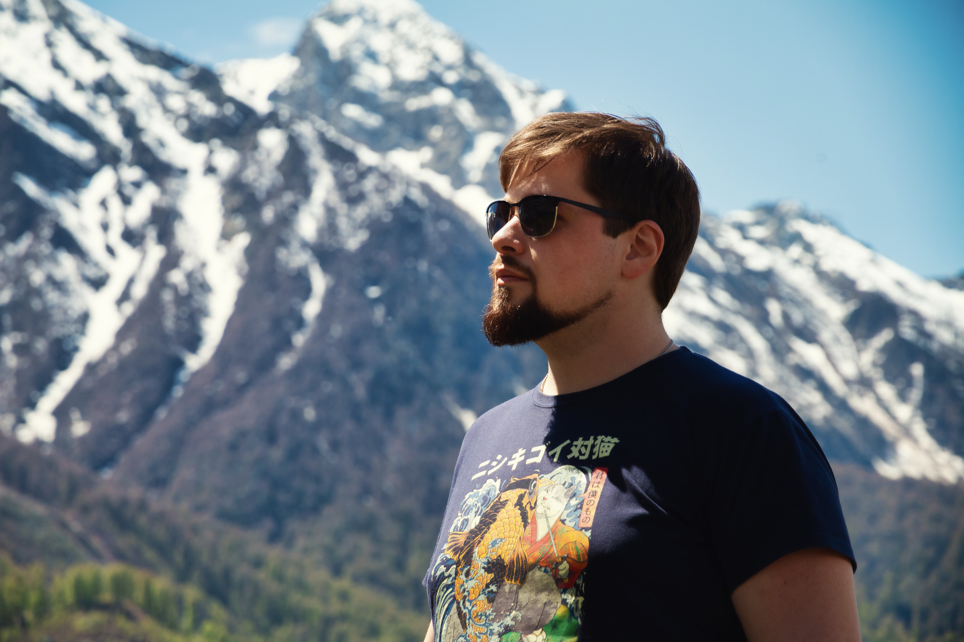 Portrait of Stas Pavlov against a snow-covered mountain landscape